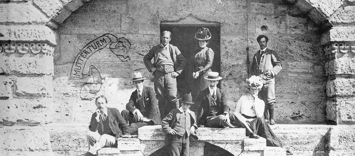 Schwarz-weiß-Foto von Hubert von Herkomer mit Frau und Schülern am Eingang des Mutterturms