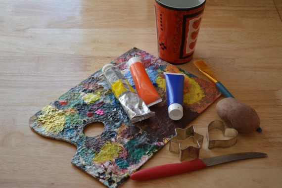 Material für Kartoffeldruck: Acrylfarben, Messer, Ausstecher, Kartoffel, Pinsel, Wasserbecher