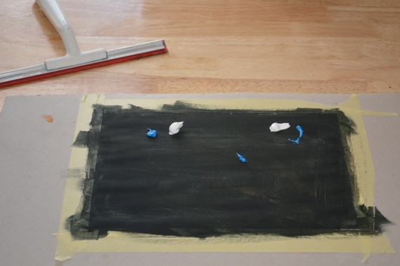 Farbe auf schwarz grundiertes Papier klecksen